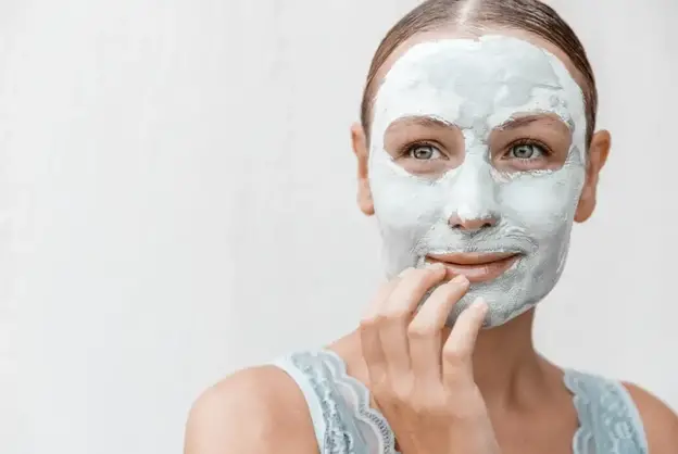 Portrait of a Woman Applying Mask Isolated on White Background. Enjoying Day Spa in Beauty Clinic.